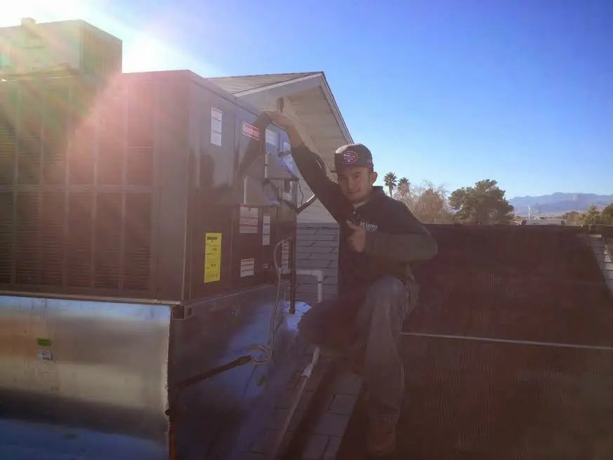 HVAC technician performing Air Duct Repair on a rooftop unit in Allendale